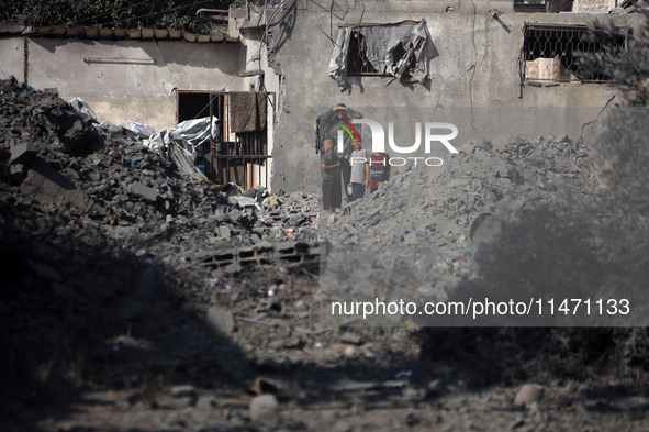 Palestinians are assessing the damage following an Israeli strike in the Nuseirat refugee camp in the central Gaza Strip on August 12, 2024,...