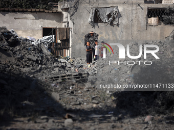 Palestinians are assessing the damage following an Israeli strike in the Nuseirat refugee camp in the central Gaza Strip on August 12, 2024,...