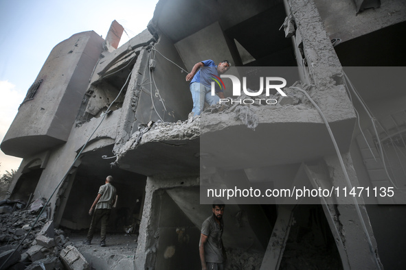 Palestinians are assessing the damage following an Israeli strike in the Nuseirat refugee camp in the central Gaza Strip on August 12, 2024,...