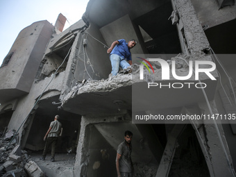 Palestinians are assessing the damage following an Israeli strike in the Nuseirat refugee camp in the central Gaza Strip on August 12, 2024,...