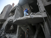 Palestinians are assessing the damage following an Israeli strike in the Nuseirat refugee camp in the central Gaza Strip on August 12, 2024,...