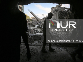 Palestinians are assessing the damage following an Israeli strike in the Nuseirat refugee camp in the central Gaza Strip on August 12, 2024,...