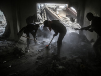 Palestinians are removing rubble from a destroyed building after an Israeli airstrike in Nuseirat, central Gaza Strip, on August 12, 2024, a...