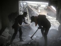 Palestinians are removing rubble from a destroyed building after an Israeli airstrike in Nuseirat, central Gaza Strip, on August 12, 2024, a...