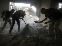 Palestinians are removing rubble from a destroyed building after an Israeli airstrike in Nuseirat, central Gaza Strip, on August 12, 2024, a...