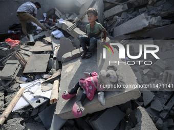 Palestinians are assessing the damage following an Israeli strike in the Nuseirat refugee camp in the central Gaza Strip on August 12, 2024,...