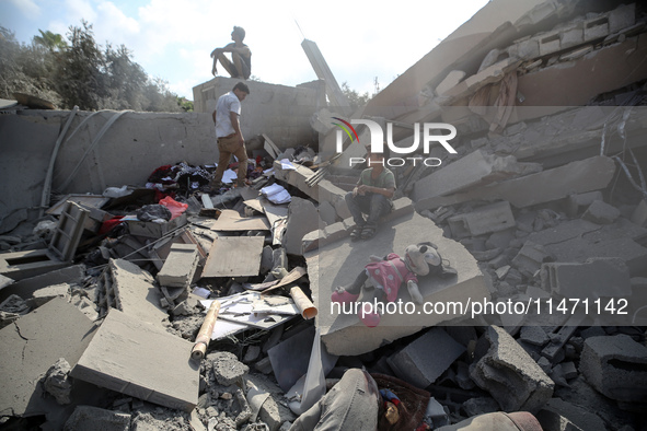 Palestinians are assessing the damage following an Israeli strike in the Nuseirat refugee camp in the central Gaza Strip on August 12, 2024,...