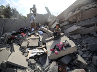 Palestinians are assessing the damage following an Israeli strike in the Nuseirat refugee camp in the central Gaza Strip on August 12, 2024,...