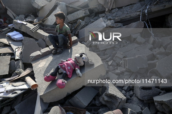 Palestinians are assessing the damage following an Israeli strike in the Nuseirat refugee camp in the central Gaza Strip on August 12, 2024,...