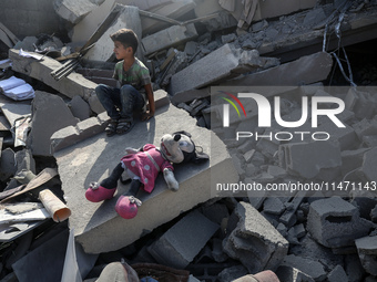 Palestinians are assessing the damage following an Israeli strike in the Nuseirat refugee camp in the central Gaza Strip on August 12, 2024,...