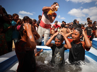 Palestinian children are playing with water and soap to cool themselves down during a heatwave at a temporary camp for the internally displa...