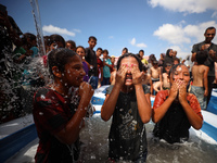 Palestinian children are playing with water and soap to cool themselves down during a heatwave at a temporary camp for the internally displa...