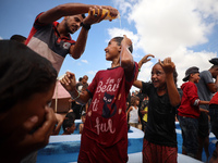 Palestinian children are playing with water and soap to cool themselves down during a heatwave at a temporary camp for the internally displa...