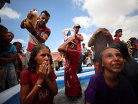 Palestinian children are playing with water and soap to cool themselves down during a heatwave at a temporary camp for the internally displa...