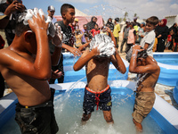 Palestinian children are playing with water and soap to cool themselves down during a heatwave at a temporary camp for the internally displa...