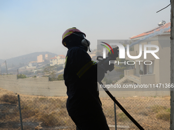 Firefighters are operating during a wildfire in Varnavas, north of Athens, on August 12, 2024. Greece is battling several wildfires on Augus...