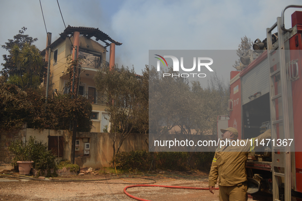 A house is burning in a wildfire in Varnavas, north of Athens, on August 12, 2024. Greece is battling several wildfires on August 11, with s...