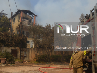 A house is burning in a wildfire in Varnavas, north of Athens, on August 12, 2024. Greece is battling several wildfires on August 11, with s...