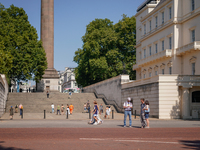 People are walking as the capital is being hit by a heatwave, which is set to bring the temperatures to 35C, in London, England, on August 1...