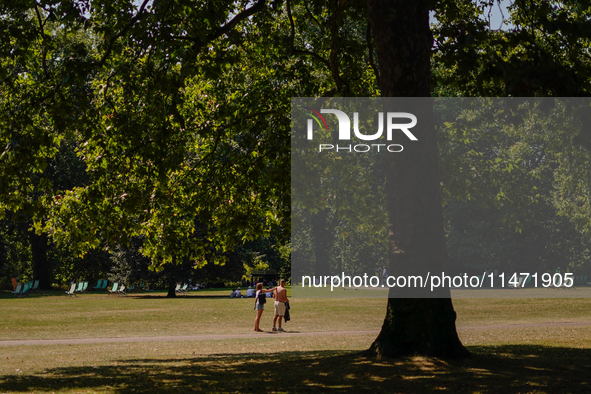 People are walking in St James's Park as the capital is being hit by a heatwave which is set to bring the temperatures to 35C, in London, En...