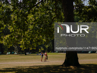 People are walking in St James's Park as the capital is being hit by a heatwave which is set to bring the temperatures to 35C, in London, En...