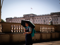 People are finding shelter under umbrellas as the capital is being hit by a heatwave, which is set to bring the temperatures to 35C, in Lond...