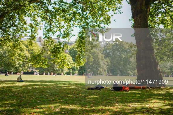 People are resting in the shade in Green Park, as the capital is being hit by a heatwave which is set to bring the temperatures to 35C, in L...