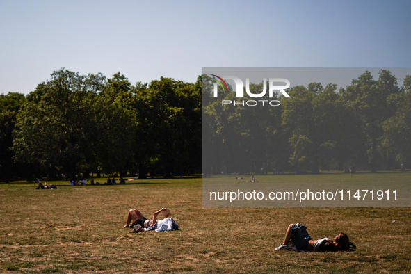 People are resting in the shade in Green Park, as the capital is being hit by a heatwave which is set to bring the temperatures to 35C, in L...