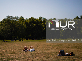 People are resting in the shade in Green Park, as the capital is being hit by a heatwave which is set to bring the temperatures to 35C, in L...