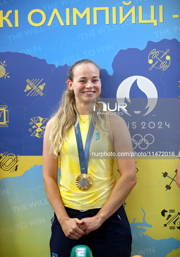 Ukrainian sabre fencer Yuliia Bakastova, who is winning gold in the Women's Sabre Team Gold Medal Match, is attending a news conference duri...