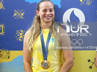 Ukrainian sabre fencer Yuliia Bakastova, who is winning gold in the Women's Sabre Team Gold Medal Match, is attending a news conference duri...