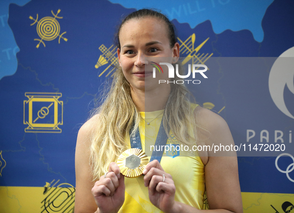 Ukrainian sabre fencer Yuliia Bakastova, who is winning gold in the Women's Sabre Team Gold Medal Match, is attending a news conference duri...