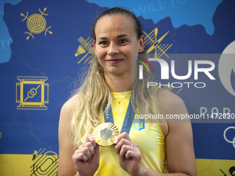 Ukrainian sabre fencer Yuliia Bakastova, who is winning gold in the Women's Sabre Team Gold Medal Match, is attending a news conference duri...