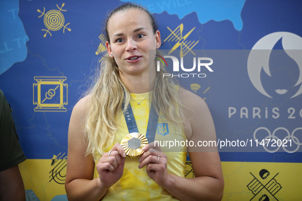 Ukrainian sabre fencer Yuliia Bakastova, who is winning gold in the Women's Sabre Team Gold Medal Match, is attending a news conference duri...