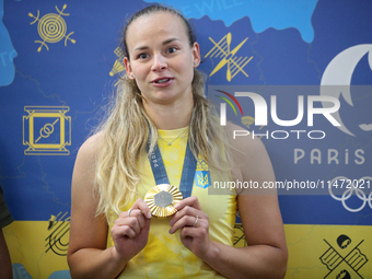 Ukrainian sabre fencer Yuliia Bakastova, who is winning gold in the Women's Sabre Team Gold Medal Match, is attending a news conference duri...