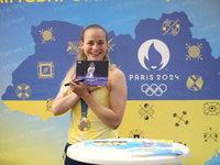 Ukrainian sabre fencer Yuliia Bakastova, who is winning gold in the Women's Sabre Team Gold Medal Match, is signing autographs during the we...