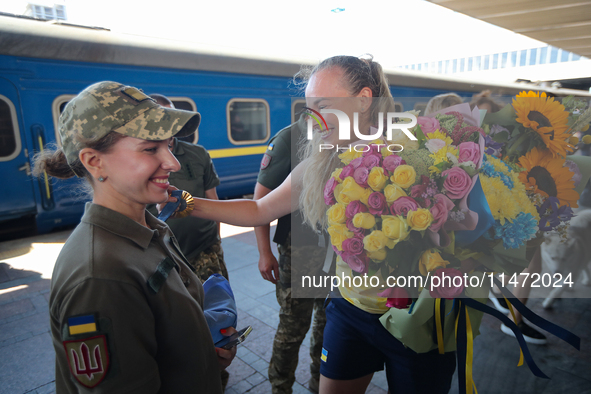 Ukrainian sabre fencer Yuliia Bakastova, who is winning gold in the Women's Sabre Team Gold Medal Match, is being greeted on the platform of...