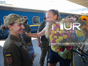 Ukrainian sabre fencer Yuliia Bakastova, who is winning gold in the Women's Sabre Team Gold Medal Match, is being greeted on the platform of...