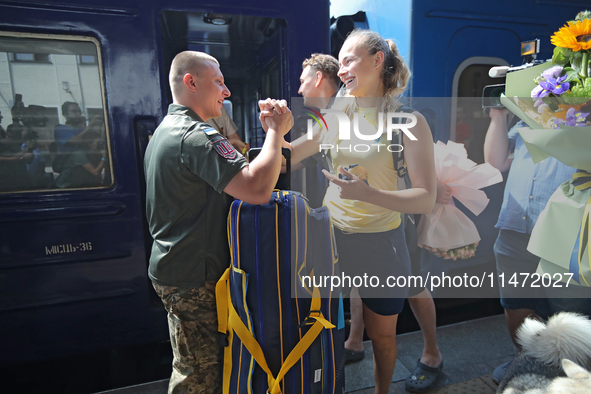 Ukrainian sabre fencer Yuliia Bakastova, who is winning gold in the Women's Sabre Team Gold Medal Match, is being greeted on the platform of...