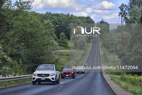 Vehicles are traveling along a steep rural road in Markham, Ontario, Canada, on August 10, 2024. 