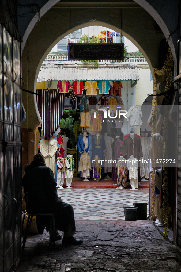 The shopkeeper is sitting by his shop as he waits for customers in Tangier, Morocco, Africa. 