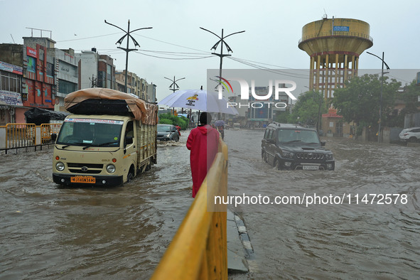 Vehicles are moving through the waterlogged Sikar Road following heavy monsoon rains in Jaipur, Rajasthan, India, on Monday, August 12, 2024...