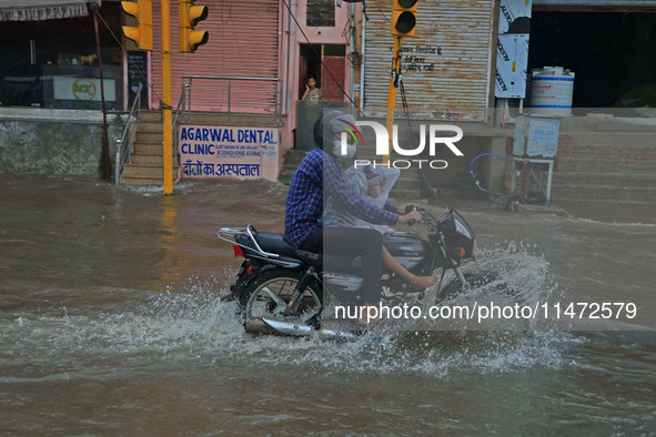 Vehicles are moving through the waterlogged Sikar Road following heavy monsoon rains in Jaipur, Rajasthan, India, on Monday, August 12, 2024...