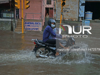 Vehicles are moving through the waterlogged Sikar Road following heavy monsoon rains in Jaipur, Rajasthan, India, on Monday, August 12, 2024...