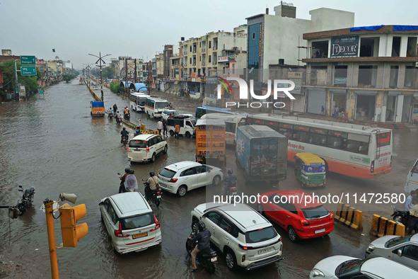 Vehicles are moving through the waterlogged Sikar Road following heavy monsoon rains in Jaipur, Rajasthan, India, on Monday, August 12, 2024...