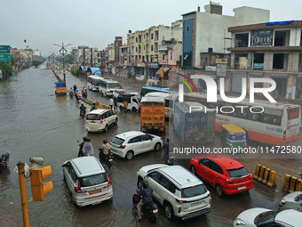 Vehicles are moving through the waterlogged Sikar Road following heavy monsoon rains in Jaipur, Rajasthan, India, on Monday, August 12, 2024...