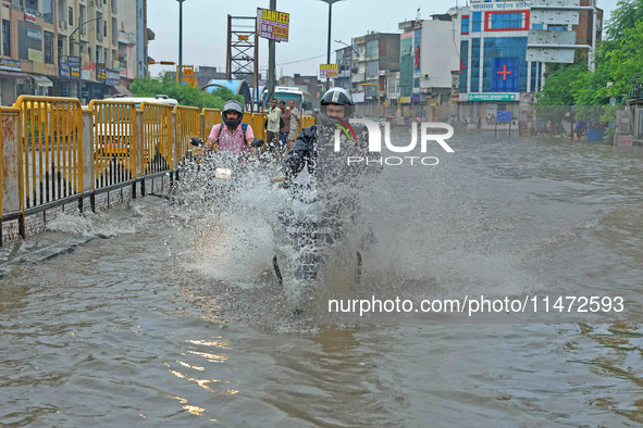 Vehicles are moving through the waterlogged Sikar Road following heavy monsoon rains in Jaipur, India, on August 12, 2024. 