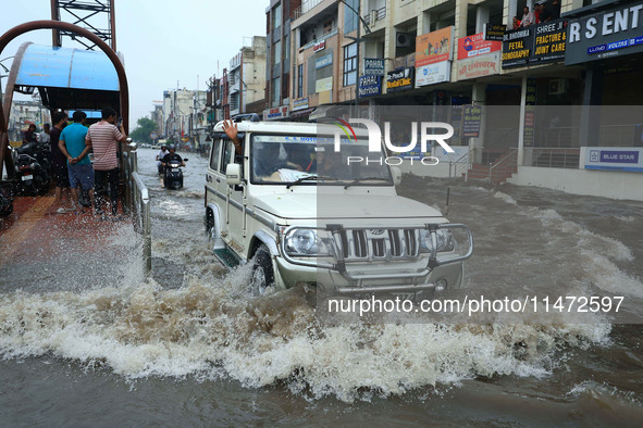 Vehicles are moving through the waterlogged Sikar Road following heavy monsoon rains in Jaipur, Rajasthan, India, on Monday, August 12, 2024...