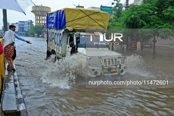 Vehicles are moving through the waterlogged Sikar Road following heavy monsoon rains in Jaipur, Rajasthan, India, on Monday, August 12, 2024...