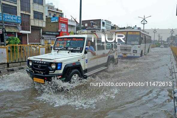 Vehicles are moving through the waterlogged Sikar Road following heavy monsoon rains in Jaipur, Rajasthan, India, on Monday, August 12, 2024...